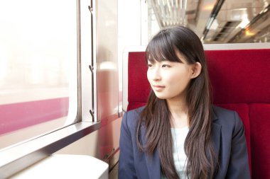 Trende oturan Asyalı kadın.