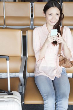 Havaalanında cep telefonu kullanan kadın 