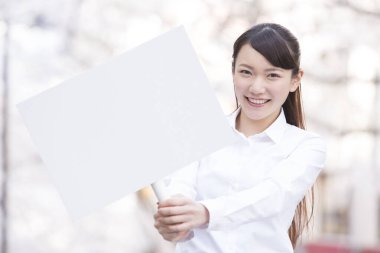 Parkta boş beyaz tahtası olan kadın. 