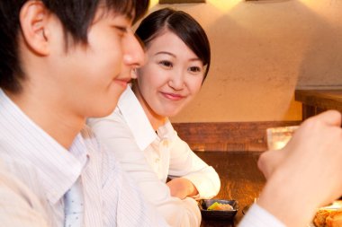 Genç çift restoranda yemek yiyor.