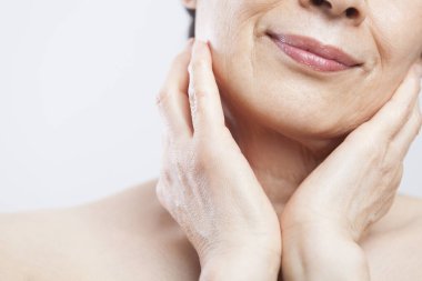 Çıplak omuzlu Asyalı yaşlı bir kadının portresi.