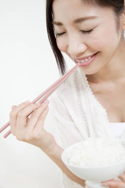 Kadın pilav ve çubuk yiyor.