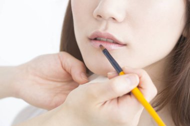 Güzellik salonunda makyaj yapan Asyalı güzel bir kadının yakın çekimi. 