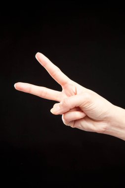 Siyah stüdyo arka planında kadın eli hareketi, yakın çekim. 