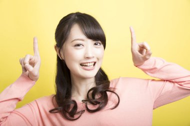 Sarı arka planda pembe elbiseli Japon kadın. 