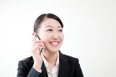 Genç iş kadını cep telefonuyla konuşuyor.