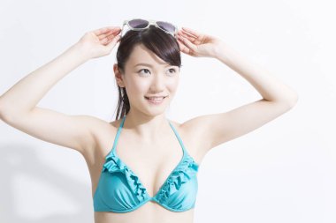 Beyaz arka planda mavi mayo giyen Japon kızın stüdyo portresi. 