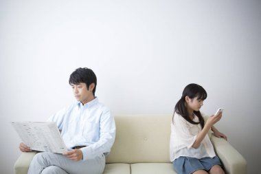 Gazeteci kadın okuyan adam akıllı telefon kullanıyor.