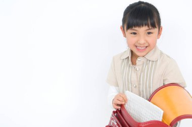 Sırt çantalı sevimli Japon kızın stüdyo portresi.