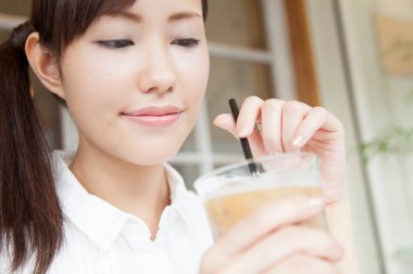 Kafede kahve içen genç bir kadın.