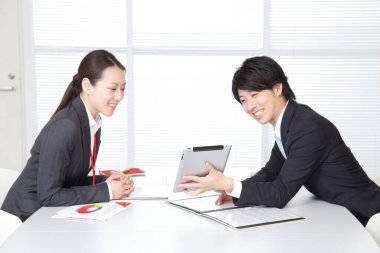 Genç iş kadını ve meslektaşı ofiste tabletle 