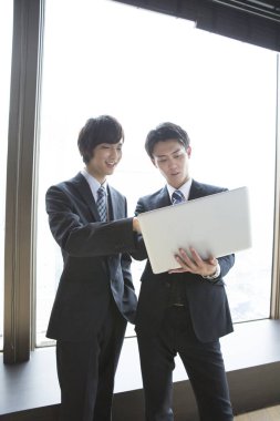 Ofiste birlikte çalışan iki genç Asyalı iş adamının portresi.