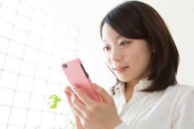 Cep telefonuna bakan bir kadın.