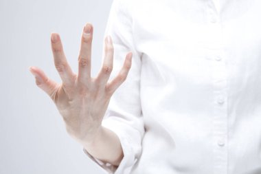 Beyaz arka planda el hareketi yapan kadınların yakın çekimi. 