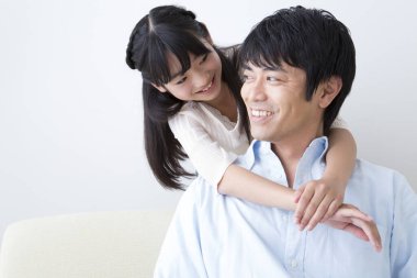 Şirin Asyalı kız babasına sarılıyor. evde aile