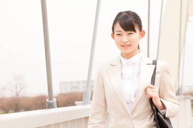 Köprüde çantası olan Asyalı kadın. 