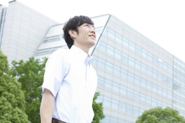 Asyalı bir adam şehirde yürüyor.