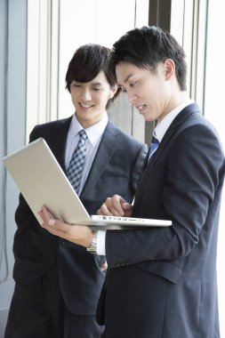 Ofiste birlikte çalışan iki genç Asyalı iş adamının portresi.