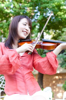 Kemanı olan genç Asyalı kadın.
