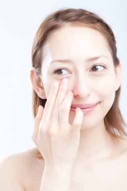 Makyaj yapan güzel genç bir kadın, beyaz arka planda yakın plan portresi