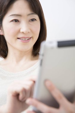 Tablet bilgisayar evine bakan kadın