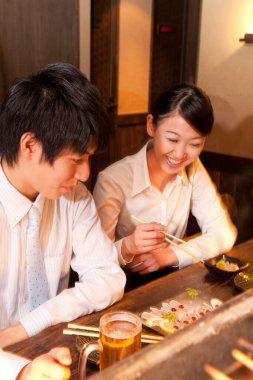 Genç çift restoranda yemek yiyor.