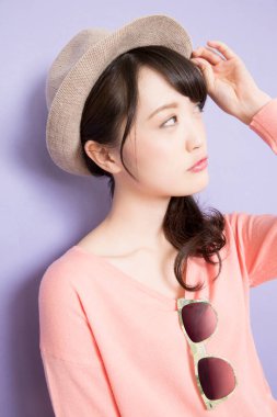 Yazlık şapkalı güzel Asyalı kadının stüdyo fotoğrafı. 