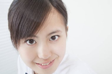 Okul üniformalı genç Japon kızın stüdyo portresi.