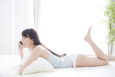 Cep telefonu yatakta kadınla