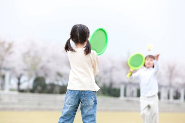 İki çocuk badminton oynuyor.