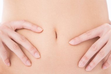 Beyaz stüdyo arka planında poz veren iç çamaşırlı bir kadın. İç çamaşırlı kadın vücuduna yakın çekim. 