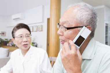 Son sınıf çifti cep telefonuyla konuşuyor. 