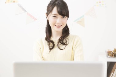 Ofiste dizüstü bilgisayar kullanan Asyalı iş kadını