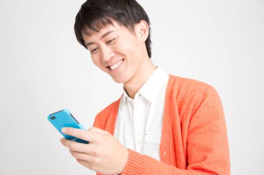 Akıllı telefon kullanan genç bir adamın portresi, stüdyo fotoğrafı.