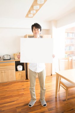 Mutfakta reklam panosu olan Asyalı bir adamın portresi..