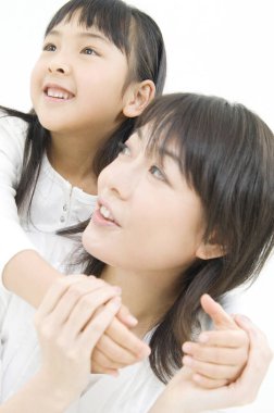 Asyalı anne ve kız stüdyoda beyazlara karşı poz veriyorlar.