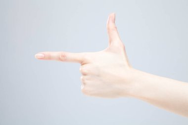 Beyaz arka planda el hareketi yapan kadınların yakın çekimi. 