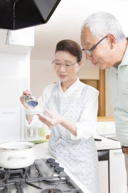 Üst düzey Asyalı çift mutfakta yemek pişiriyor.