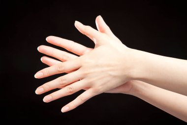 Siyah stüdyo arka planında kadın eli hareketi, yakın çekim. 