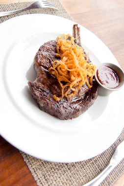 Beyaz tabakta servis edilen ızgara lezzetli et.