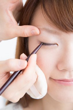 Güzellik salonunda makyaj yapan Asyalı güzel bir kadının yakın çekimi. 