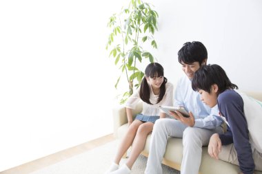 Üç kişilik genç bir aile tablet kullanıyor.