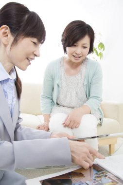 İki kadın kanepede belgeleri tartışıyor.