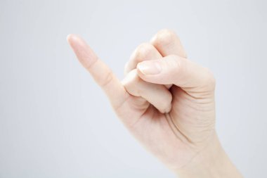 Beyaz arka planda el hareketi yapan kadınların yakın çekimi. 