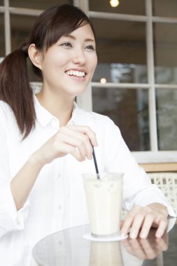 Kafede kahve içen genç bir kadın.