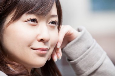 Genç ve güzel Asyalı bir kadının açık hava portresini kapat.