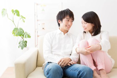 Genç Asyalı çift kanepede birbirine aşık.