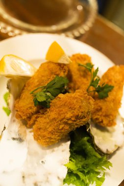 Tabaktaki yeşil marul yapraklarının üzerindeki balık nugget görüntüsünü kapat. 