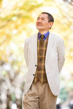 Parkta yürüyen kıdemli iş adamı.