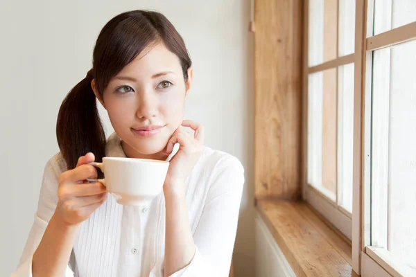 young japanese woman drinking coffee at home